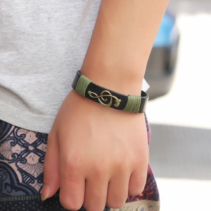 Retro black leather bracelet featuring a bronze treble clef charm and green woven rope