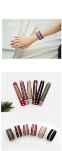 Detailansicht von sechs bunten Mikrofaser-Armbändern mit Glitzersteinen und Metalldruckknopf
