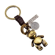 Dettaglio portachiavi orso in bronzo vintage con pelle e ciondoli in metallo