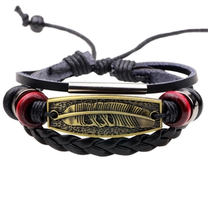 Mehrlagiges Lederarmband mit Vintage-Federanhänger und roten Perlen auf weißem Hintergrund