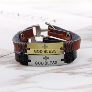 Vintage cross leather bracelet set with bronze God Bless metal plates on marble base