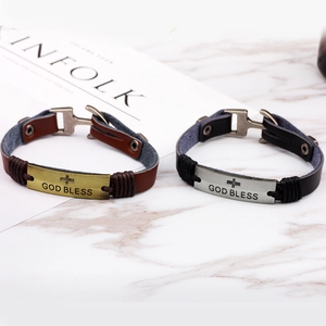 Vintage leather cross bracelet set with metal God Bless engraved plates on marble