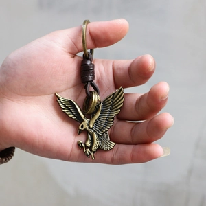 Classic eagle metal keychain in vintage bronze finish with woven leather strap detail