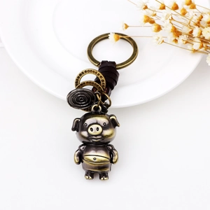 Porte-clés cochon en bronze vintage avec cuir tressé marron et anneaux métalliques