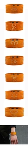 Details von lasergravierten Tierkreiszeichen auf braunen Lederarmbändern mit Druckknöpfen