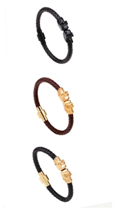 Three men's woven leather bracelets with skull charms in black, gold, and brown colors