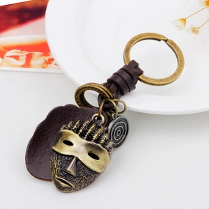 Vintage tribal mask keychain with woven leather strap and bronze metal accents for cars