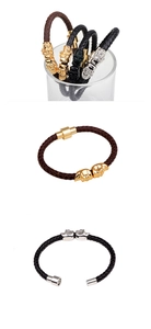 Detail showing various leather braided punk bracelets with skull charms and metal buckles