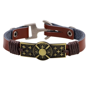 Retro brown leather bracelet with bronze sun and stars metal plaque on a white backdrop