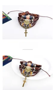 Detail eines mehrlagigen Lederarmbands mit Perlen und bronzefarbenem Kreuzanhänger