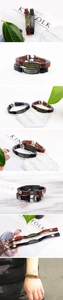 Detail view of vintage leather bracelets with feather metal plates and anchor closures
