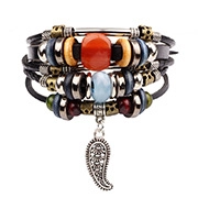 Close-up of bohemian multilayer leather bracelet with colorful beads and leaf pendant