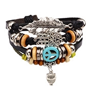 Detail of multilayer leather bracelet with silver leaf and owl charms in retro ethnic style