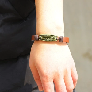 Vintage brown leather bracelet featuring a bronze feather pendant for men