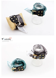 Close-up of silk paisley scarf bracelets with black leather buckle and gold studs