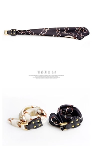 Detail eines Seidenschal-Armbands mit bedrucktem Kettenmuster und goldener Lederschnalle