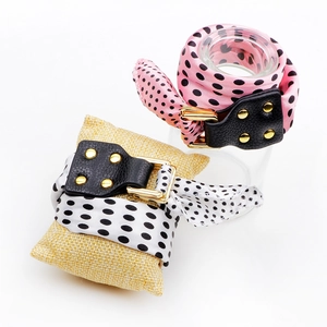 Polka dot silk scarf bracelet with leather buckle and gold studs on display