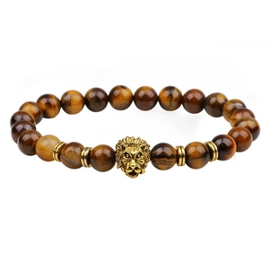 Macro shot of tiger eye beads with a golden lion head charm on a beaded bracelet