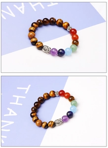 Macro detail of tiger eye stone beads with seven chakra colors and silver Buddha head bead