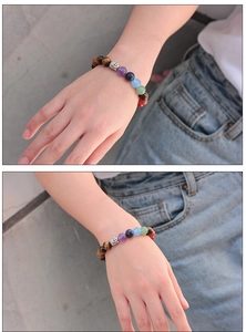 Macro view of multi-color tiger eye beads bracelet with a silver Buddha head charm