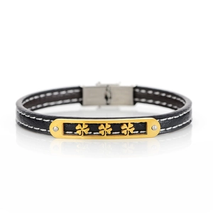 Detail of black lychee leather bracelet with white stitching and gold clover metal plate