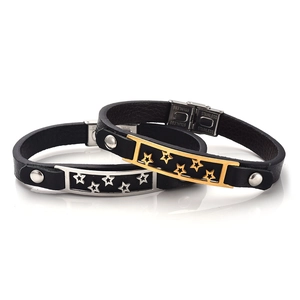 Dettaglio di bracciali in pelle nera con motivi a stella e chiusure in acciaio inox