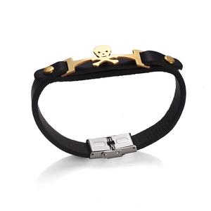 Detail of black leather punk bracelet featuring a gold skull charm and stainless steel clasp