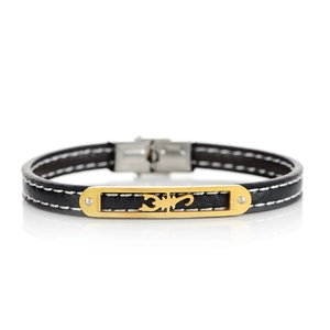 Detail of black leather bracelet with white stitching and gold scorpion metal plate