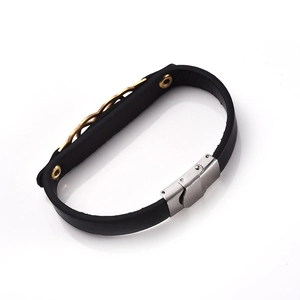 Detailed macro of black leather bracelet with silver stainless steel clasp and gold accents