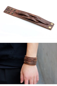 Détail du bracelet large en cuir marron vintage avec tresses et boutons-pression en métal