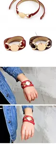 Detail of multi-layer PU leather bracelet with custom round gold charms in red and brown