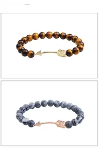 Détail de bracelets perlés avec œil de tigre, agate et breloques flèches en zircons