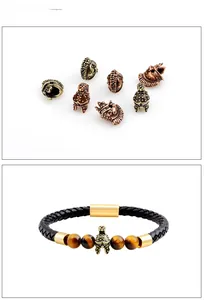 Detail von Lederarmband mit goldenem Römerhelm-Anhänger und Tigerauge-Steinperlen