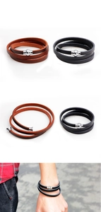 Detail of multi-layer leather bracelets in black and brown with magnetic metal clasps