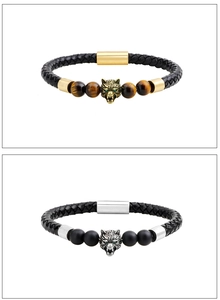 Détail de bracelets en cuir tressé avec têtes de loup et perles d'oeil de tigre