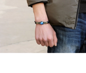 Détail d'un bracelet zodiaque vintage avec bracelet en cuir bleu foncé et breloque bronze