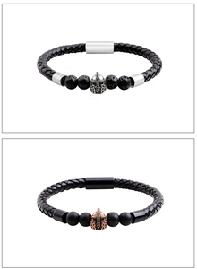 Dettaglio di bracciali in pelle con ciondoli a elmo spartano e chiusure magnetiche in acciaio