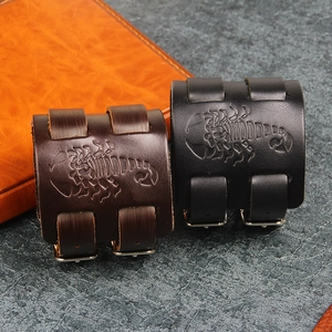 Close-up of leather cuff bracelets with embossed scorpion pattern and silver buckles