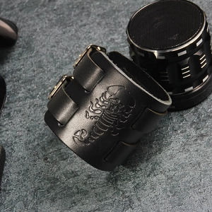 Detail of wide black leather punk bracelet with scorpion relief and metal buckle straps
