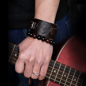 Detailed view of genuine leather wolf head wristband with beaded bracelet and guitar
