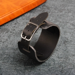 Macro detail of black leather bracelet featuring silver metal buckle and adjustable holes