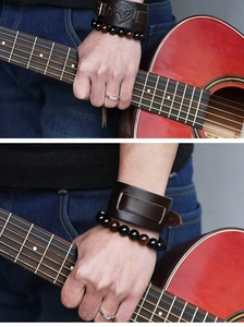 Detail of embossed wolf head leather cuff with vintage rock beads on guitarist