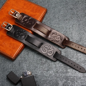 Gros plan de bracelets en cuir vintage avec symbole Om embossé et boucle en métal