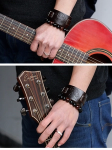 Detail of vintage eagle embossed leather cuff and stone bead bracelet for men