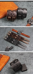 Detail of vintage leather wristband with embossed paw print and metal buckle adjustment