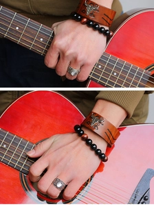 Detail of punk leather wristband with bull head charm and beaded stone bracelets