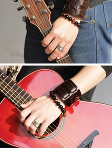 Detail of vintage leather wristband with bear paw imprint and bohemian beaded bracelets