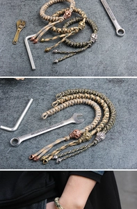 Detail of paracord bracelets with copper skull charms and industrial tool props