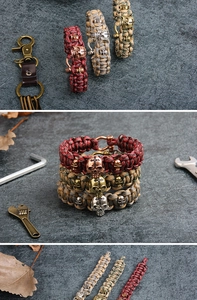 Detail of paracord bracelets with metal skull charms and U-shaped buckles on stone surface