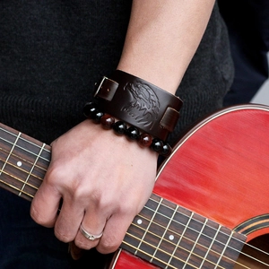 Vintage eagle relief brown leather cuff with beaded bracelet on a guitarist's hand